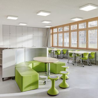 Neubau Klassenhaus und Sporthalle Gymnasium Alstertal Innenraum einer Schule mit grünen Stühlen